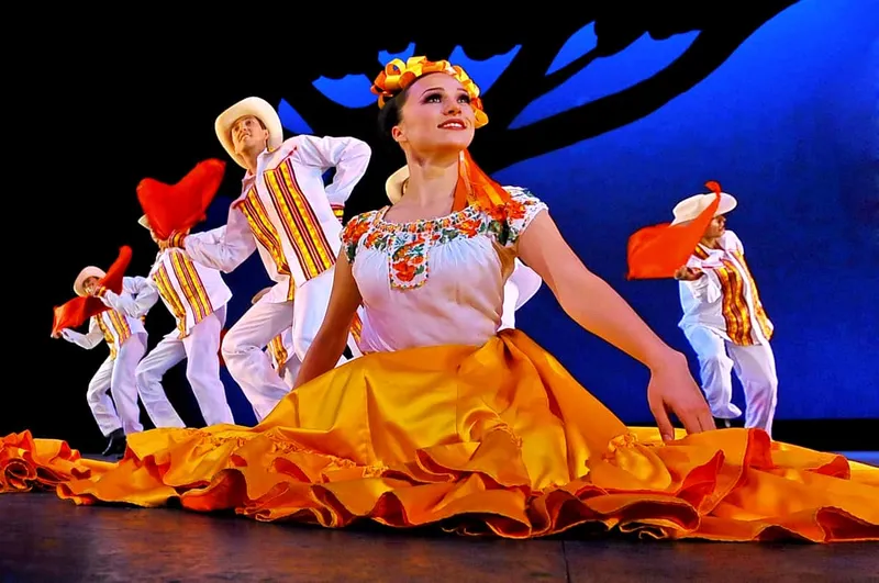 Dancers in bright regional costume on the Bellas Artes stage, a cultural pairing with museums in Mexico City