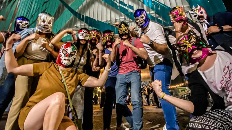 Masked Lucha Libre wrestlers mid-match under arena lights, a cultural pairing with museums in Mexico City